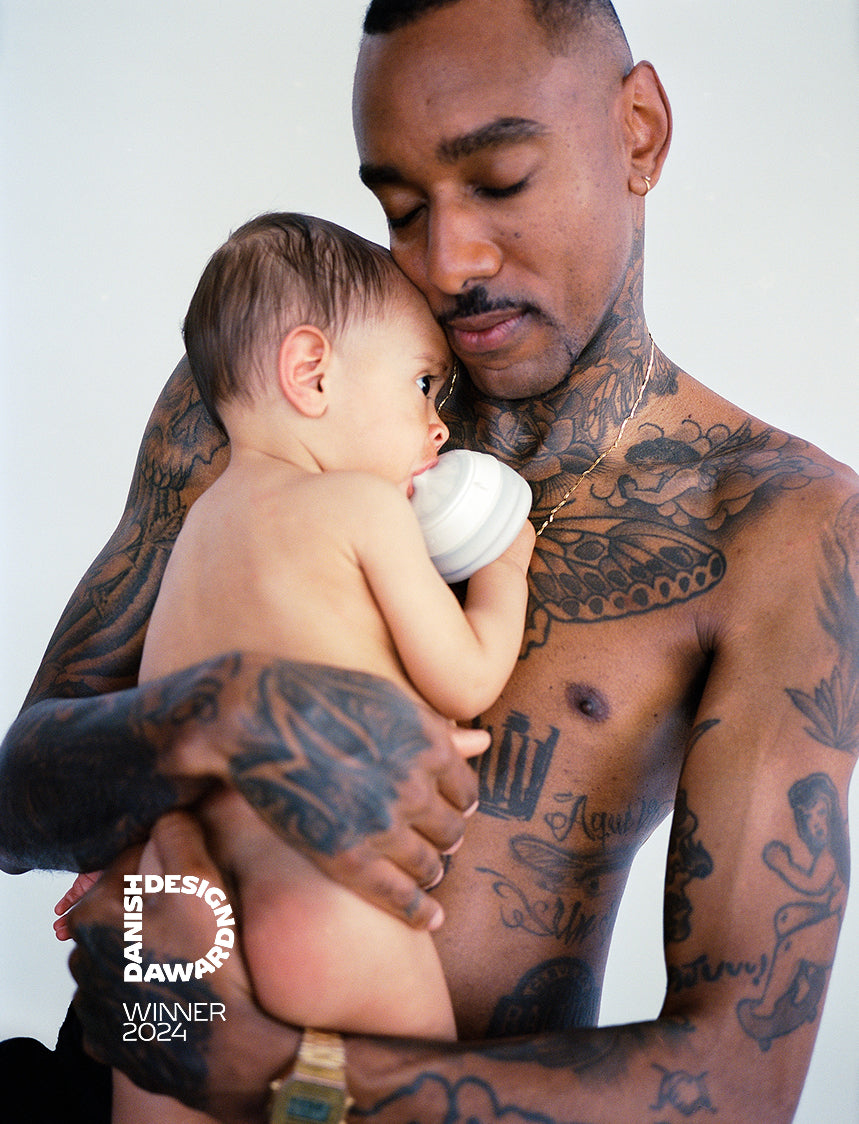 Dad using Caramma baby bottle to bond with baby during late-night feeding for full intimacy and skin-to-skin. Petra Kleis
